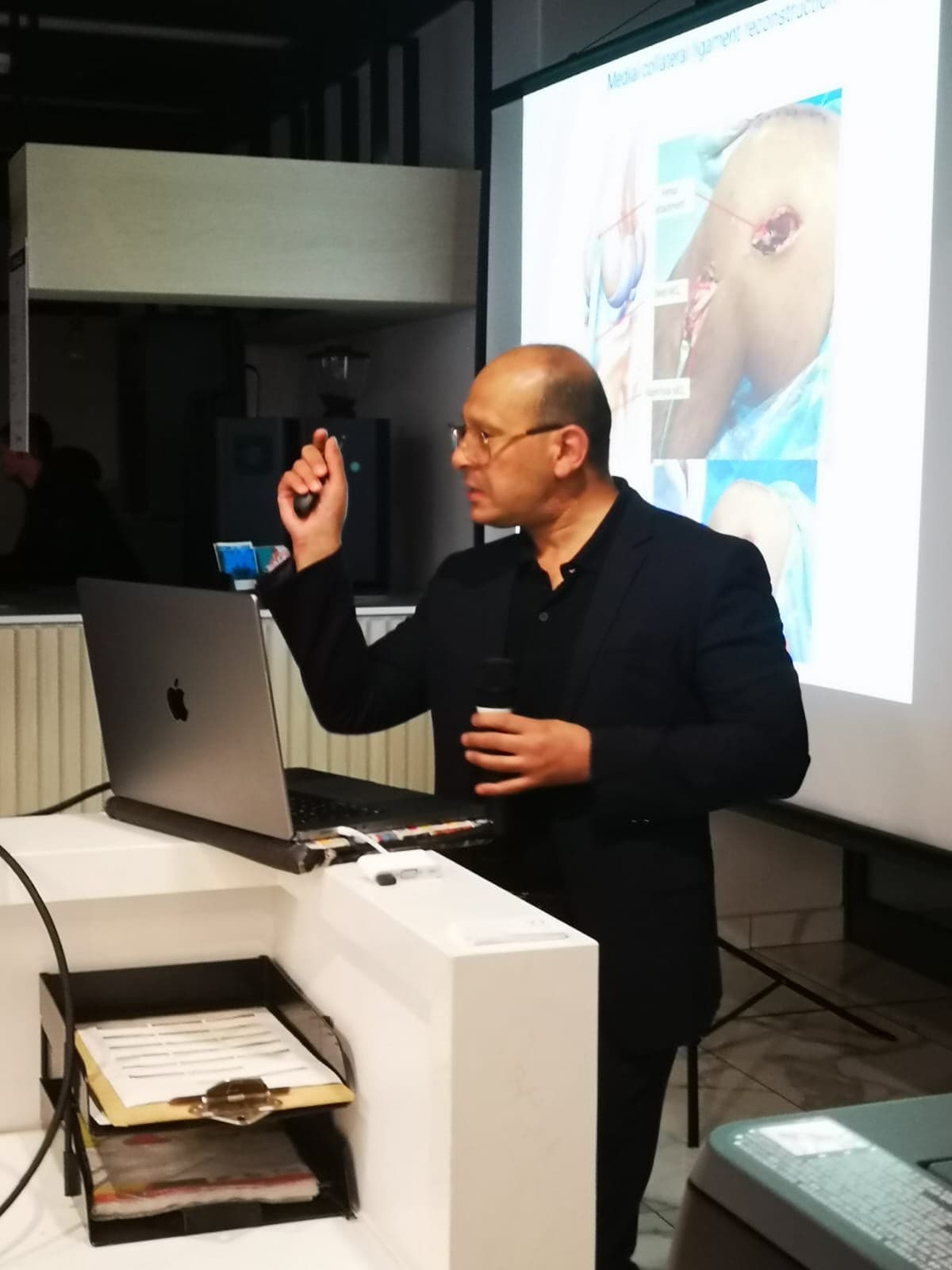 Orthopaedic speaker explaining ligament reconstruction at a MedTalk Network CME meeting